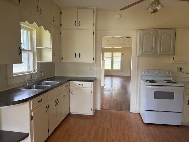 714 W Leyda Ave, West Plains, MO 65775 - kitchen featuring white electric range oven, light wood-style flooring, plenty of natural light, and dark countertops