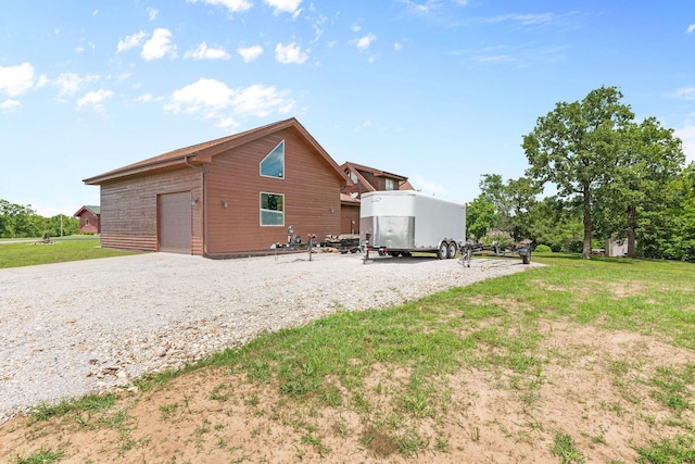 78 Free Bird Ln, Reeds Spring, MO 65737 - rear view of property featuring a garage, gravel driveway, and a yard