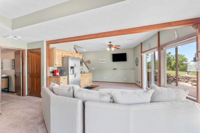 78 Free Bird Ln, Reeds Spring, MO 65737 - living area featuring light colored carpet, ceiling fan, beamed ceiling, and a textured ceiling