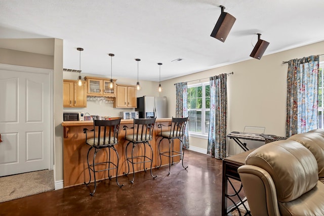 4050 W Page Pl, Springfield, MO 65802 - kitchen with stainless steel appliances, concrete floors, a kitchen bar, glass insert cabinets, and a peninsula
