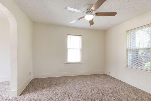 1921 W Atlantic St, Springfield, MO 65803 - carpeted spare room with arched walkways, a textured ceiling, and a ceiling fan