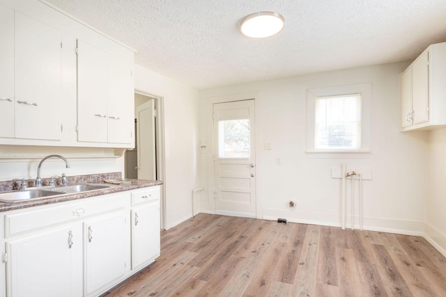 1921 W Atlantic St, Springfield, MO 65803 - kitchen with a textured ceiling, white cabinetry, light wood-style floors, and light countertops