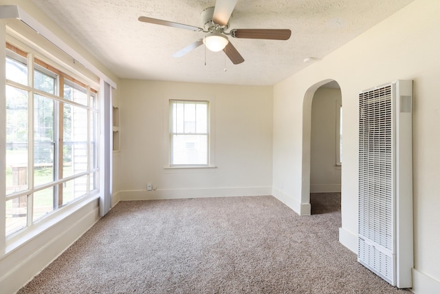 1921 W Atlantic St, Springfield, MO 65803 - spare room with a heating unit, arched walkways, a textured ceiling, carpet flooring, and ceiling fan