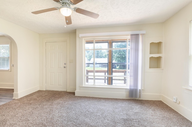 1921 W Atlantic St, Springfield, MO 65803 - spare room with arched walkways, a textured ceiling, carpet floors, and plenty of natural light