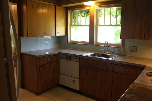 1305 S Kimbrough Ave, Springfield, MO 65807 - kitchen featuring dishwasher, tasteful backsplash, brown cabinetry, and light tile patterned flooring