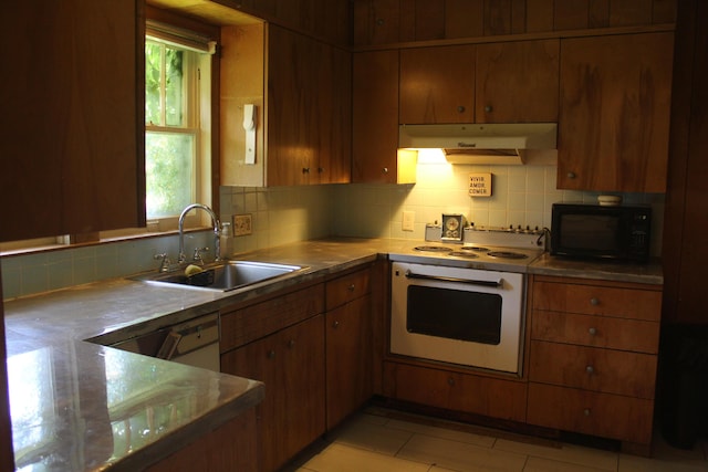 1305 S Kimbrough Ave, Springfield, MO 65807 - kitchen featuring white oven, black microwave, under cabinet range hood, and tasteful backsplash
