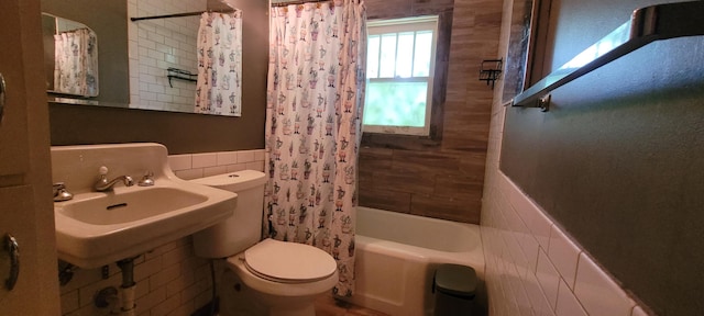 1305 S Kimbrough Ave, Springfield, MO 65807 - bathroom featuring tile walls, shower / bath combo with shower curtain, and a wainscoted wall