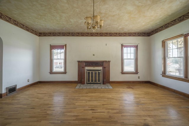 400 S Jefferson St, Neosho, MO 64850 - unfurnished living room featuring a chandelier, wood finished floors, a premium fireplace, and arched walkways