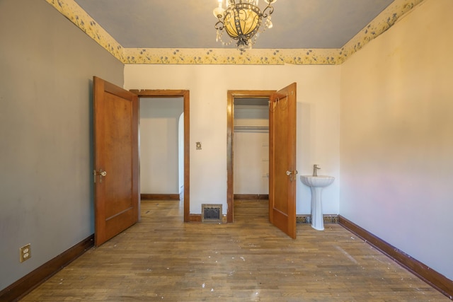 400 S Jefferson St, Neosho, MO 64850 - unfurnished bedroom featuring a chandelier, hardwood / wood-style flooring, and a closet