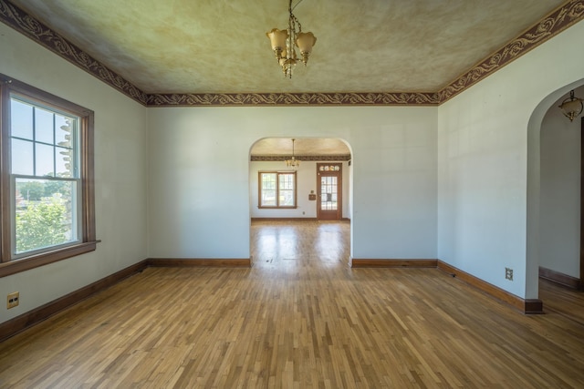 400 S Jefferson St, Neosho, MO 64850 - unfurnished room featuring arched walkways, hardwood / wood-style flooring, and a chandelier