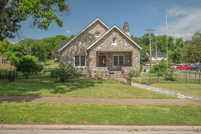 400 S Jefferson St, Neosho, MO 64850 - tudor house with a chimney, stone siding, and a fenced front yard