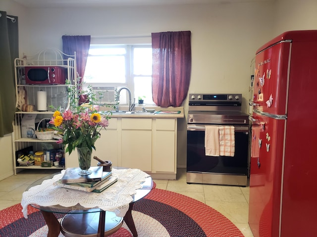 1108 E Cleveland Ave, Monett, MO 65708 - kitchen with freestanding refrigerator, electric stove, light tile patterned floors, and light countertops