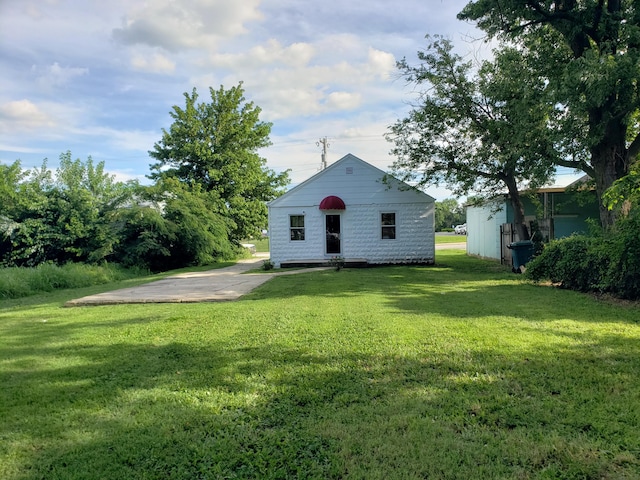1108 E Cleveland Ave, Monett, MO 65708 - rear view of house featuring a lawn