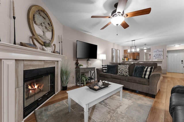 366 Wimbledon Dr Unit 4, Branson, MO 65616 - living room featuring light wood-style floors, a ceiling fan, a fireplace, and a chandelier