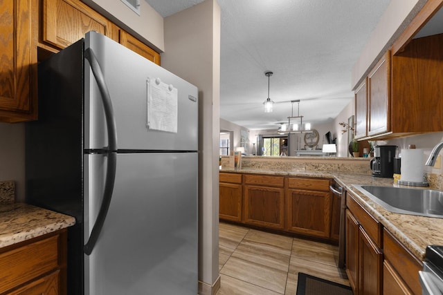 366 Wimbledon Dr Unit 4, Branson, MO 65616 - kitchen with freestanding refrigerator, brown cabinets, decorative light fixtures, and range