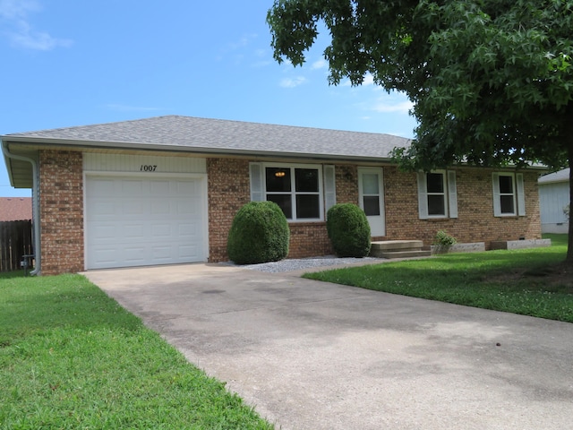 1007 E Parkview St, Ozark, MO 65721 - single story home with concrete driveway, brick siding, a garage, and a front lawn
