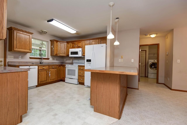 1030 Harris Blvd, Ozark, MO 65721 - kitchen with white appliances, washer / dryer, brown cabinetry, a peninsula, and hanging light fixtures