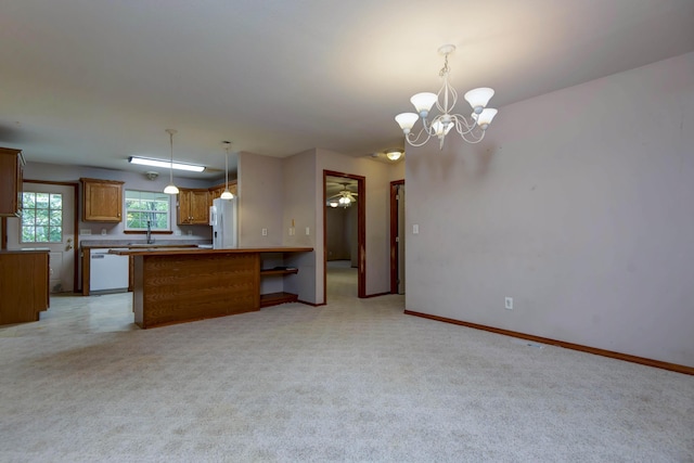1030 Harris Blvd, Ozark, MO 65721 - kitchen featuring white appliances, a chandelier, a peninsula, and light carpet