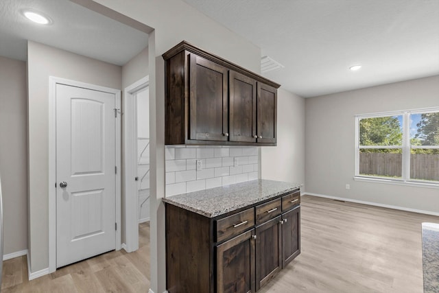 200 E Rosalie St, Strafford, MO 65757 - kitchen with light wood-type flooring, dark brown cabinetry, decorative backsplash, light stone counters, and recessed lighting