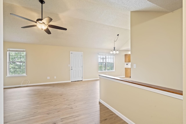 1813 Boswell Ave, Branson, MO 65616 - empty room featuring vaulted ceiling, a textured ceiling, healthy amount of natural light, light wood-style flooring, and ceiling fan
