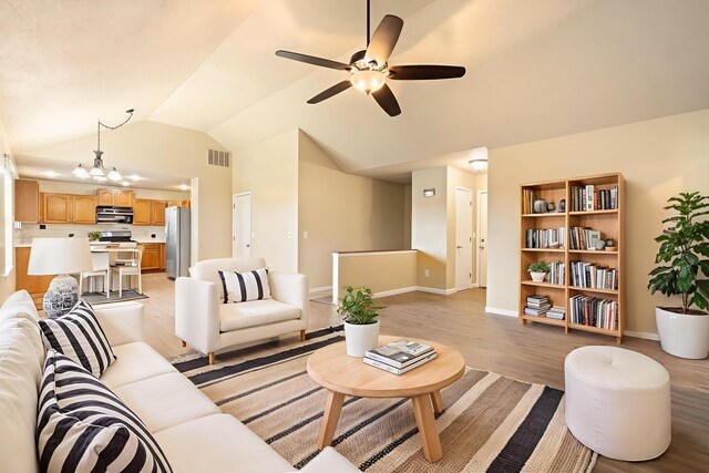 1813 Boswell Ave, Branson, MO 65616 - living area featuring light wood-style flooring, lofted ceiling, ceiling fan, and a chandelier