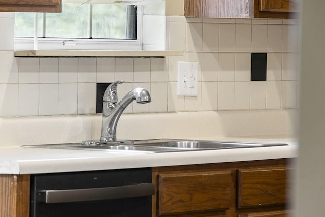 1813 Boswell Ave, Branson, MO 65616 - kitchen view of stainless steel dishwasher, light countertops, decorative backsplash, and brown cabinetry