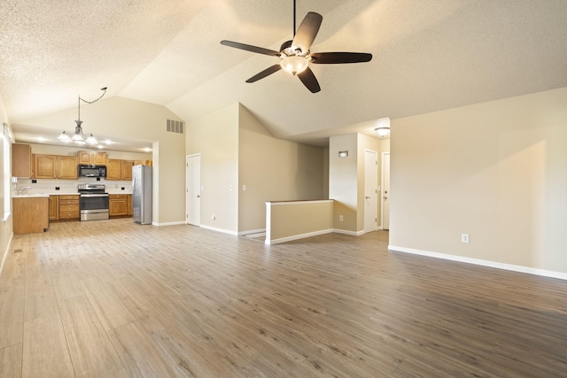 1813 Boswell Ave, Branson, MO 65616 - unfurnished living room with lofted ceiling, wood finished floors, a ceiling fan, a textured ceiling, and a chandelier