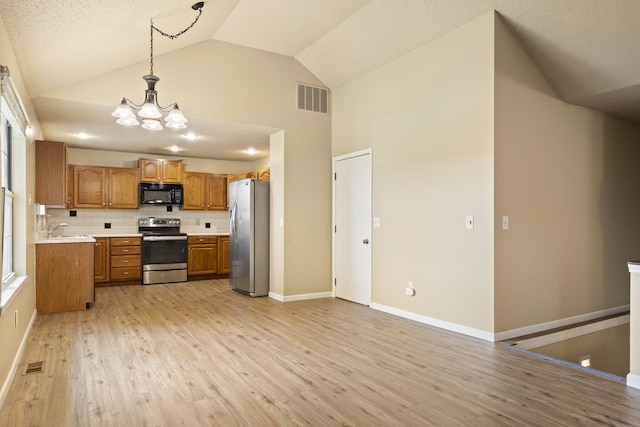 1813 Boswell Ave, Branson, MO 65616 - kitchen with stainless steel appliances, brown cabinetry, a chandelier, light wood-type flooring, and high vaulted ceiling