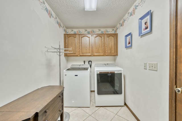 636 Crader Ct, Springfield, MO 65802 - washroom featuring washer and dryer, cabinet space, a textured ceiling, and light tile patterned flooring