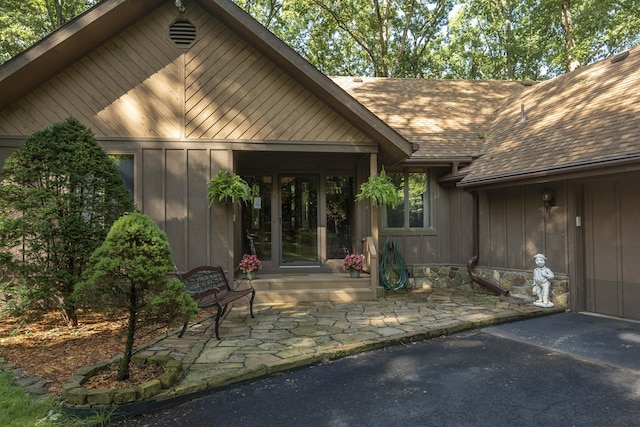 636 Crader Ct, Springfield, MO 65802 - doorway to property with board and batten siding, a shingled roof, and a patio