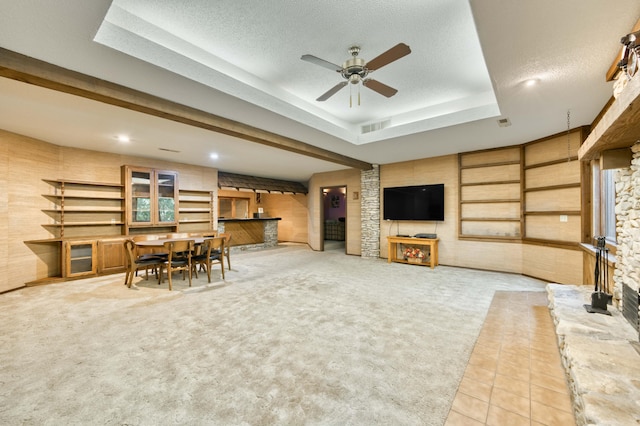 636 Crader Ct, Springfield, MO 65802 - tiled living area featuring a fireplace, a ceiling fan, a tray ceiling, carpet, and a textured ceiling