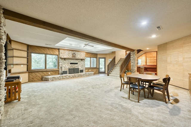 636 Crader Ct, Springfield, MO 65802 - dining area featuring wood walls, a stone fireplace, a ceiling fan, stairway, and carpet flooring