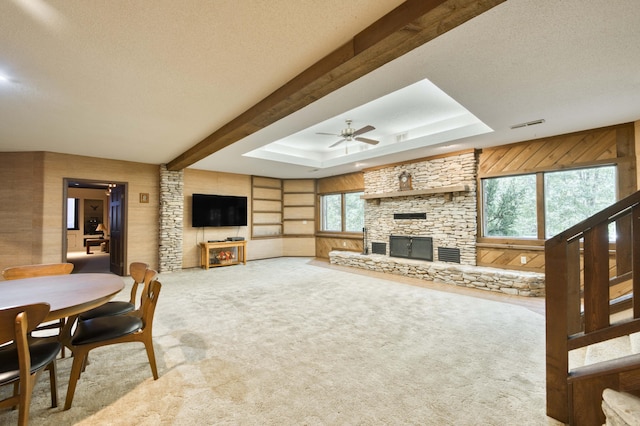 636 Crader Ct, Springfield, MO 65802 - living room with a ceiling fan, a stone fireplace, a textured ceiling, carpet floors, and a raised ceiling
