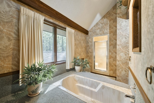 636 Crader Ct, Springfield, MO 65802 - bathroom with vaulted ceiling, wallpapered walls, a tub to relax in, and a textured ceiling