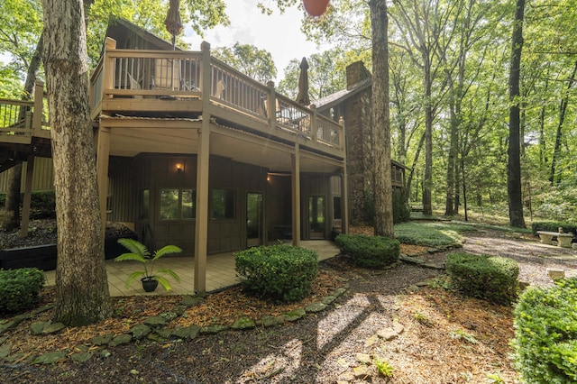 636 Crader Ct, Springfield, MO 65802 - back of house featuring board and batten siding, a deck, a chimney, and a patio