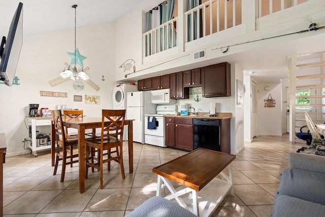 440 Fall Creek Dr Unit 7, Branson, MO 65616 - kitchen featuring white appliances, high vaulted ceiling, estacked washer and dryer, light tile patterned flooring, and light countertops