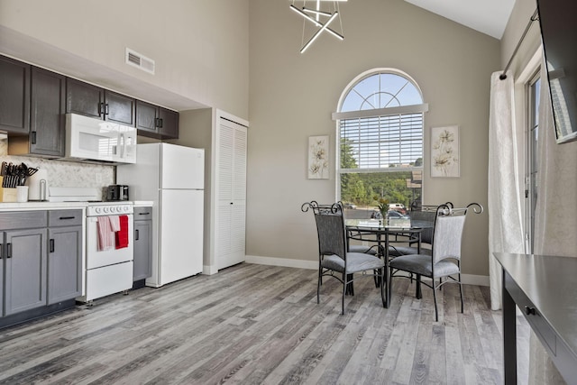 530 Abby Ln Unit 5, Branson, MO 65616 - kitchen featuring white appliances, high vaulted ceiling, light wood-style floors, decorative backsplash, and light countertops