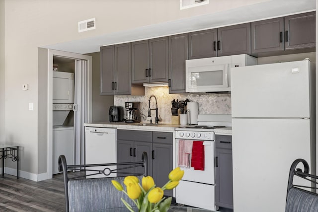 530 Abby Ln Unit 5, Branson, MO 65616 - kitchen featuring white appliances, estacked washer and dryer, light countertops, decorative backsplash, and dark wood-style floors