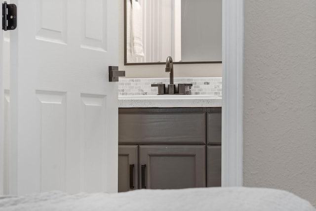 530 Abby Ln Unit 5, Branson, MO 65616 - bathroom featuring vanity, backsplash, and a textured wall