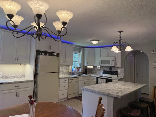 2304 E Huntington St, Ozark, MO 65721 - kitchen featuring white appliances, a chandelier, arched walkways, tasteful backsplash, and a textured ceiling