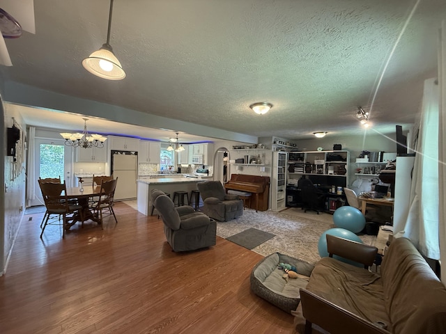 2304 E Huntington St, Ozark, MO 65721 - living area featuring a chandelier, a textured ceiling, and light wood finished floors