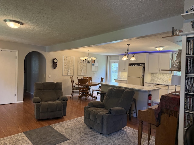 2304 E Huntington St, Ozark, MO 65721 - living room featuring arched walkways, a textured ceiling, dark wood-style floors, and a chandelier