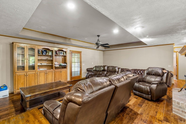 641 N Park Pl, Bolivar, MO 65613 - living room featuring a raised ceiling, a textured ceiling, dark wood-type flooring, and a ceiling fan