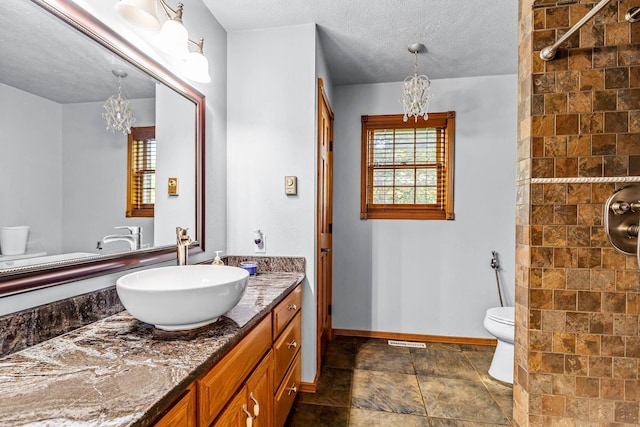 641 N Park Pl, Bolivar, MO 65613 - bathroom featuring a chandelier, vanity, tiled shower, stone finish floors, and a textured ceiling