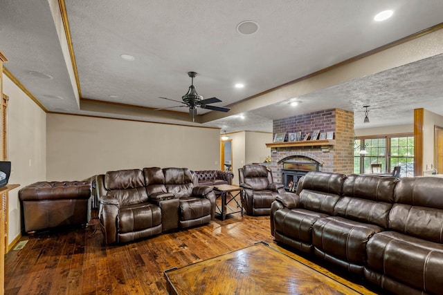 641 N Park Pl, Bolivar, MO 65613 - living area featuring a textured ceiling, wood-type flooring, ceiling fan, a fireplace, and crown molding