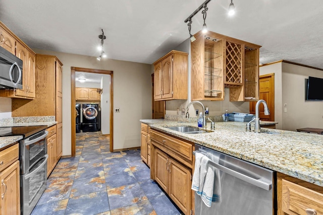 641 N Park Pl, Bolivar, MO 65613 - kitchen featuring stainless steel appliances, independent washer and dryer, track lighting, light stone counters, and stone finish floors