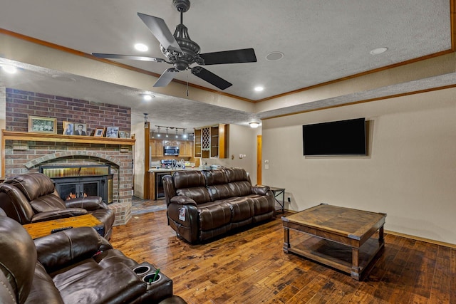 641 N Park Pl, Bolivar, MO 65613 - living room with hardwood / wood-style floors, a ceiling fan, a fireplace, ornamental molding, and a textured ceiling
