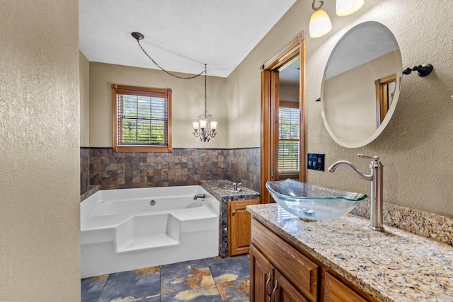 641 N Park Pl, Bolivar, MO 65613 - full bath with stone finish flooring, vanity, a bath, a textured wall, and tile walls