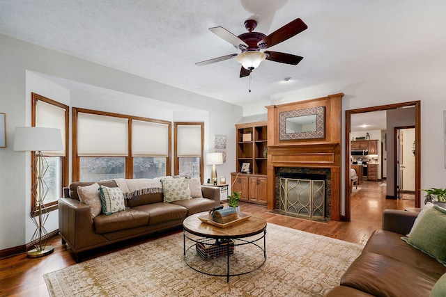 3449 S Woodstock Dr, Springfield, MO 65809 - living area with light wood finished floors, ceiling fan, and a premium fireplace