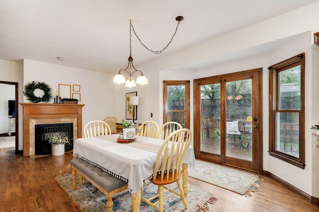 3449 S Woodstock Dr, Springfield, MO 65809 - dining area featuring wood finished floors, a premium fireplace, a chandelier, and french doors